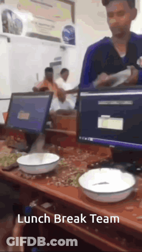 A Man Standing In Front Of A Desk With Bowls On It And The Words Lunch Break Team On The Bottom GIF