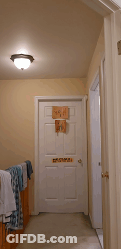 Man Standing In Front Of Bad Boy Door Sign GIF