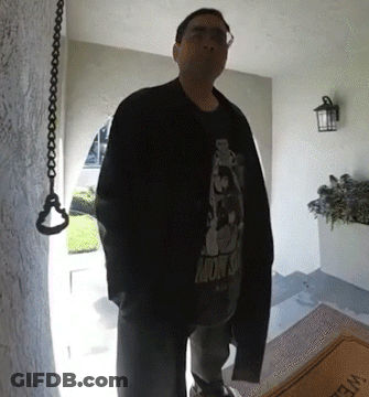 A Man Standing In Front Of A Door Wearing A Shirt That Says Monsoon GIF