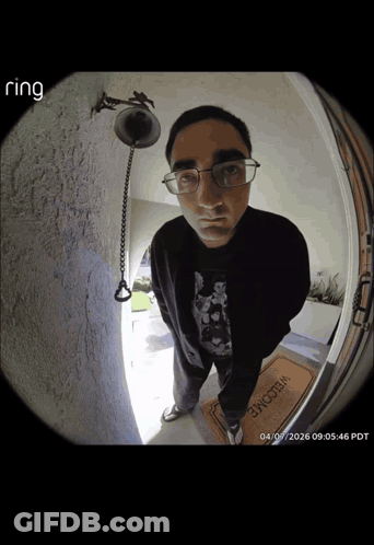 A Man Standing In Front Of A Door With A Welcome Mat GIF