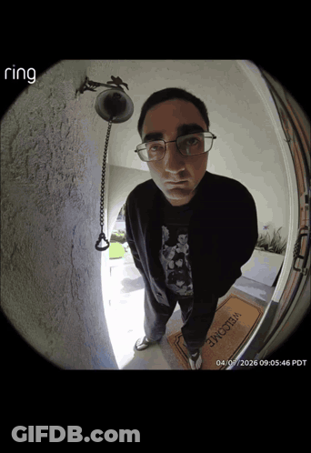 A Man Standing In Front Of A Door With A Welcome Mat GIF