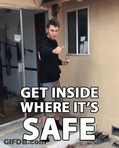 A Man Standing In Front Of A Door With The Words Get Inside Where It 'S Safe Above Him GIF