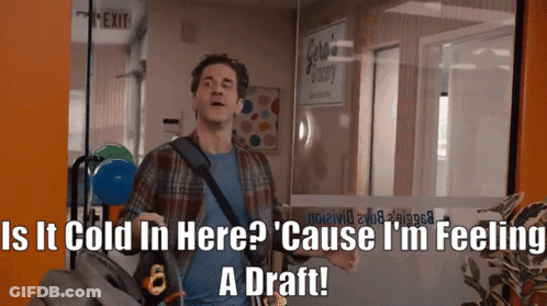 A Man Standing In Front Of A Glass Door With The Words " Is It Cold In Here " Written On It GIF