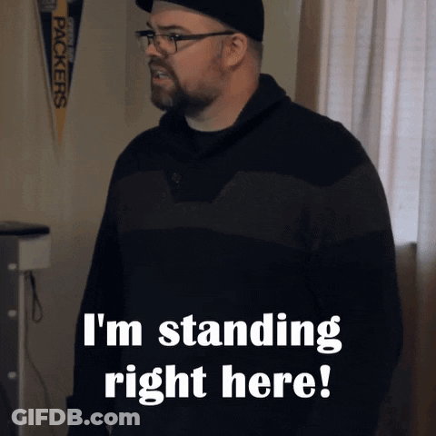 A Man Standing In Front Of A Green Bay Packers Banner That Says I 'M Standing Right Here GIF