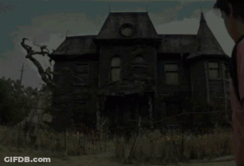 A Man Standing In Front Of A Haunted House GIF