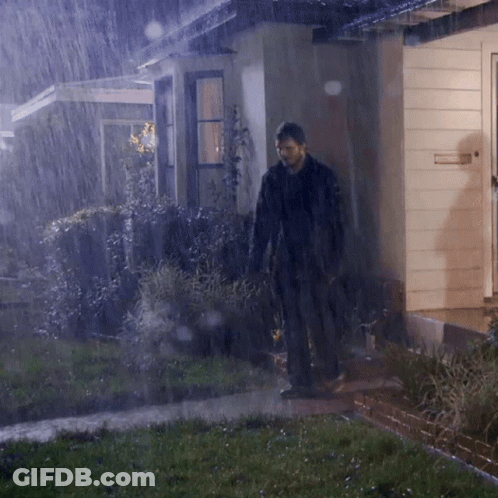 A Man Standing In Front Of A House With A Sign On The Door That Says Emergency Exit GIF
