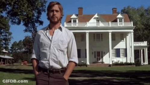 A Man Standing In Front Of A Large White House With His Hands In His Pockets GIF