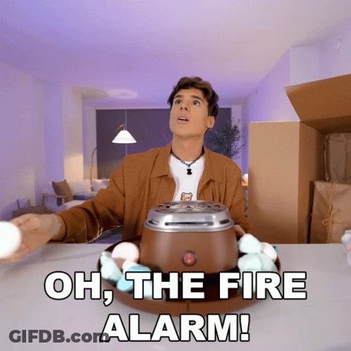 A Man Standing In Front Of A Marshmallow Maker With The Words Oh The Fire Alarm Written Below Him GIF