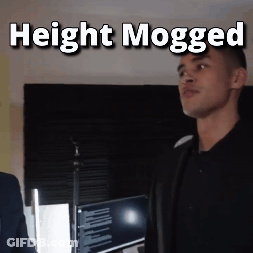 A Man Standing In Front Of A Microphone With The Words " Height Mogged " Above Him GIF