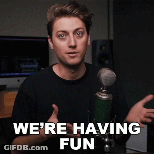 A Man Standing In Front Of A Microphone With The Words We 'Re Having Fun Above Him GIF