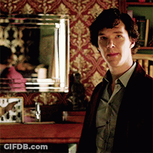 A Man Standing In Front Of A Mirror With A Clock On It GIF
