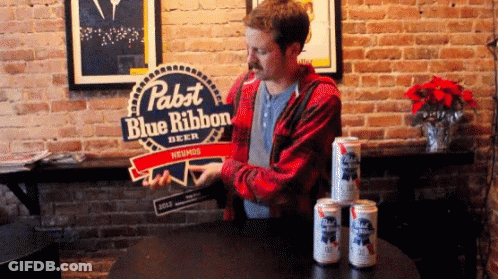 A Man Standing In Front Of A Pabst Blue Ribbon Sign GIF