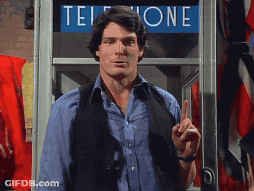 A Man Standing In Front Of A Phone Booth That Says Telephone GIF