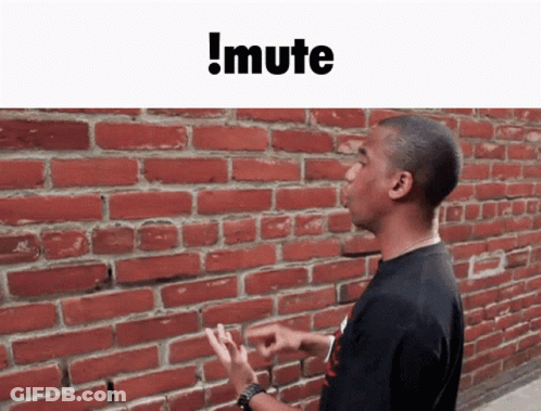 A Man Standing In Front Of A Red Brick Wall With The Words !Mute Above Him GIF