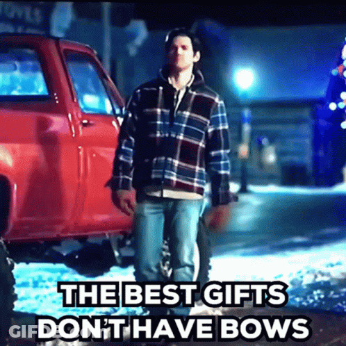 A Man Standing In Front Of A Red Truck With The Words " The Best Gifts Don T Have Bows " GIF