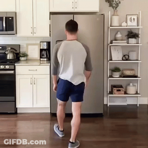 A Man Standing In Front Of A Refrigerator That Says ' Ice ' On It GIF