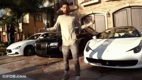 A Man Standing In Front Of A Row Of Cars GIF