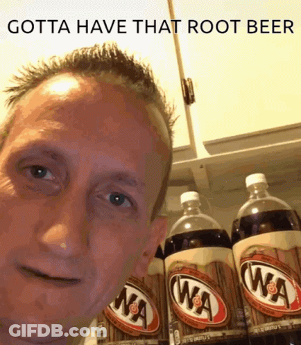 A Man Standing In Front Of A Shelf Of Root Beer GIF