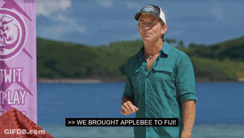 A Man Standing In Front Of A Sign That Says Twit Play GIF
