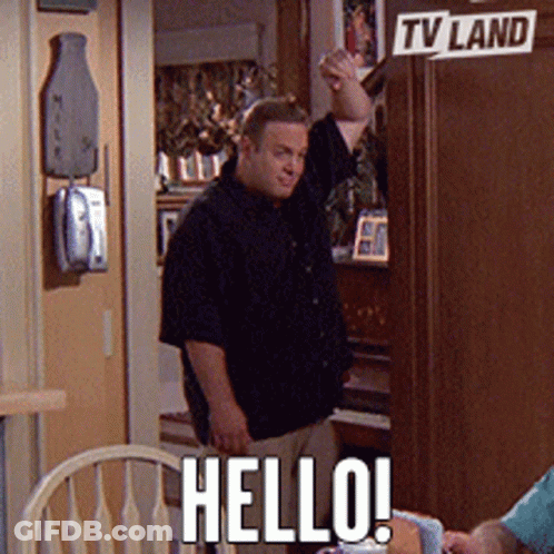 A Man Standing In Front Of A Tv Land Sign Says Hello GIF