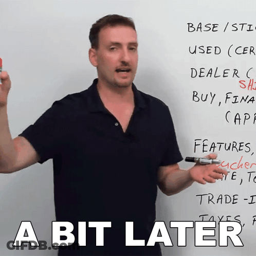 A Man Standing In Front Of A White Board With The Words A Bit Later GIF