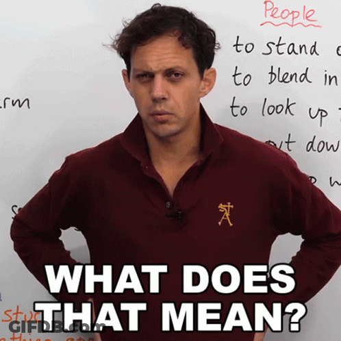 A Man Standing In Front Of A White Board With The Words " What Does That Mean " Written On It GIF