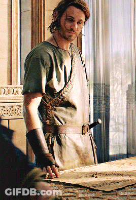 A Man Standing In Front Of A Window Wearing A Green Shirt And Brown Belt GIF