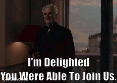A Man Standing In Front Of A Window With The Words " I 'M Delighted You Were Able To Join Us " Written Below GIF