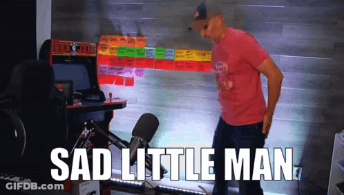 A Man Standing In Front Of An Arcade Machine That Says " Sad Little Man " On It GIF