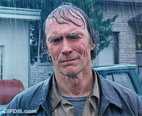 A Man Standing In The Rain With Wet Hair GIF
