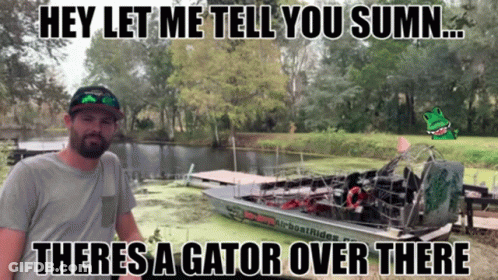 A Man Standing Next To A Boat That Says Airboat Rides On The Side GIF