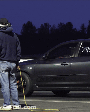 A Man Standing Next To A Car That Has The Number 740 On The Door GIF