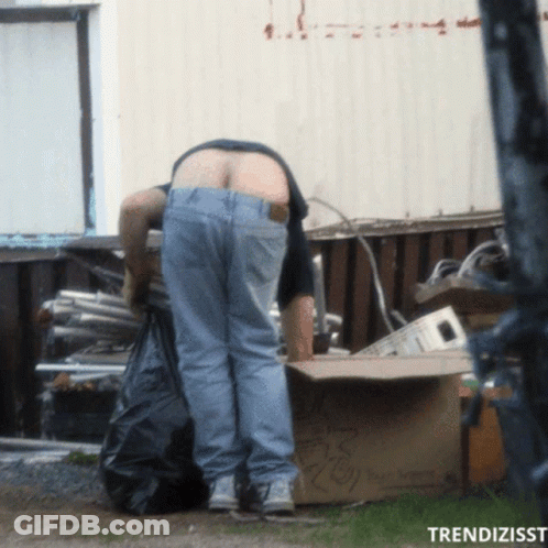 A Man Standing Next To A Cardboard Box That Says ' Recycling ' GIF