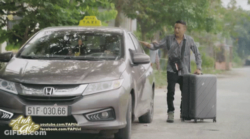 A Man Standing Next To A Honda Car With A Taxi Sign On The Top GIF