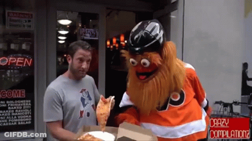 A Man Standing Next To A Mascot Holding A Pizza In Front Of A Store That Says Open GIF