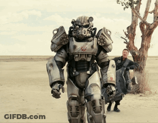 A Man Standing Next To A Robot In A Field GIF
