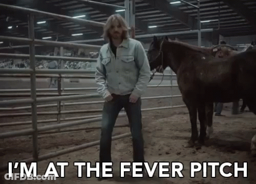 A Man Standing Next To Two Horses With The Words I 'M At The Fever Pitch GIF