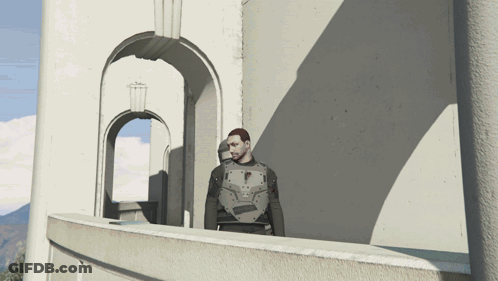 A Man Standing On A Balcony In Front Of A Building GIF