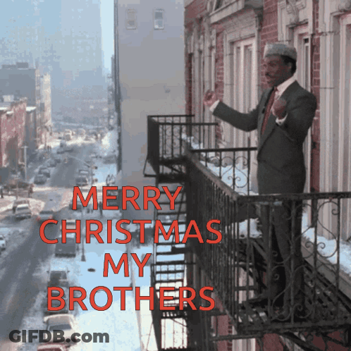 A Man Standing On A Balcony With The Words Merry Christmas My Brothers GIF