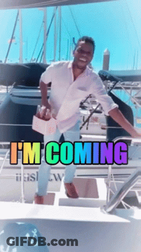 A Man Standing On A Boat With The Words " I 'M Coming " On It GIF