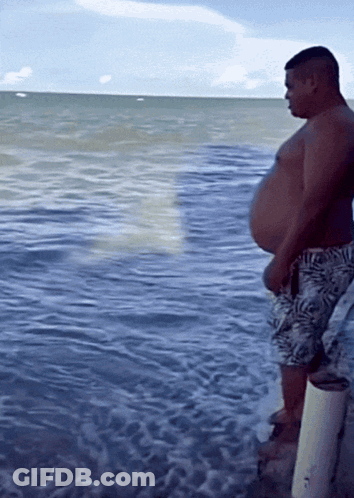 Man Standing On Dock Looking At Ocean GIF