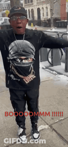 A Man Standing On A Sidewalk With His Arms Outstretched And The Words Boooommm Written In Red GIF