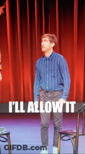 A Man Standing On A Stage With The Words " I 'Ll Allow It " On The Bottom GIF
