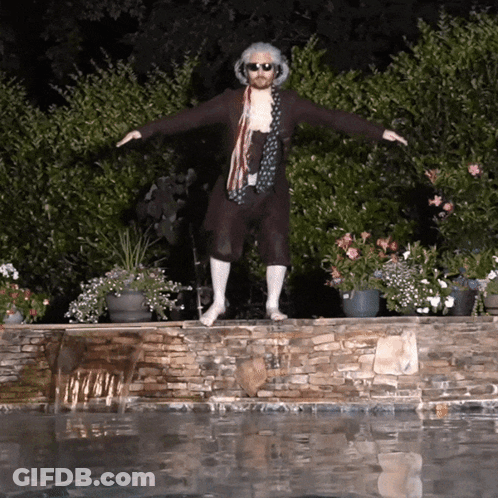 A Man Standing On A Stone Wall Next To A Pool GIF