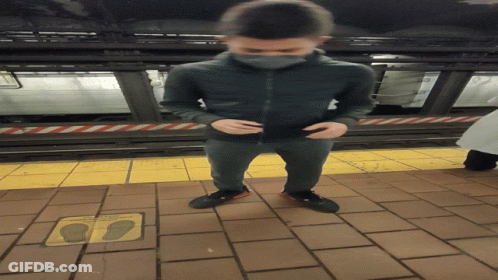 A Man Standing On A Tiled Floor Next To A Sign That Says " Do Not Walk On The Sidewalk " GIF