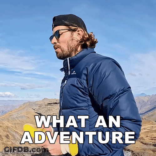 A Man Standing On Top Of A Mountain With The Words What An Adventure Written Below Him GIF