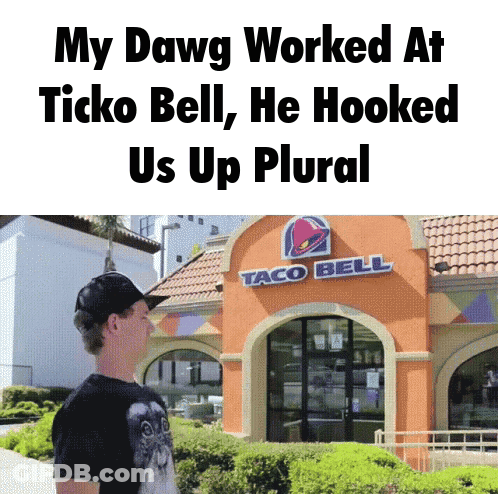 A Man Standing Outside Of A Taco Bell Restaurant GIF