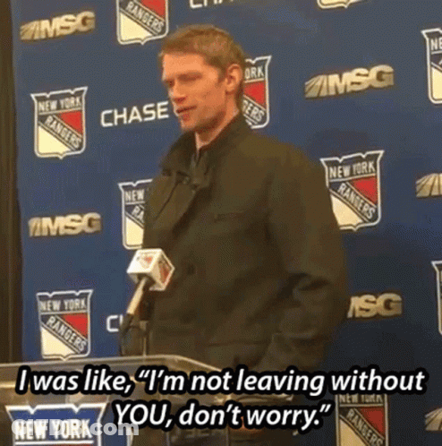 A Man Stands At A Podium With A Microphone In Front Of A Wall With New York Rangers Logos On It GIF