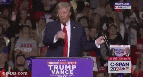 A Man Stands At A Podium With A Sign That Says Trump Vance GIF