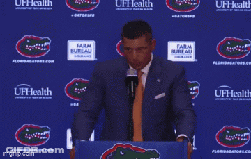 A Man Stands At A Podium With The Words Well I Don 'T Hire My Friends Behind Him GIF